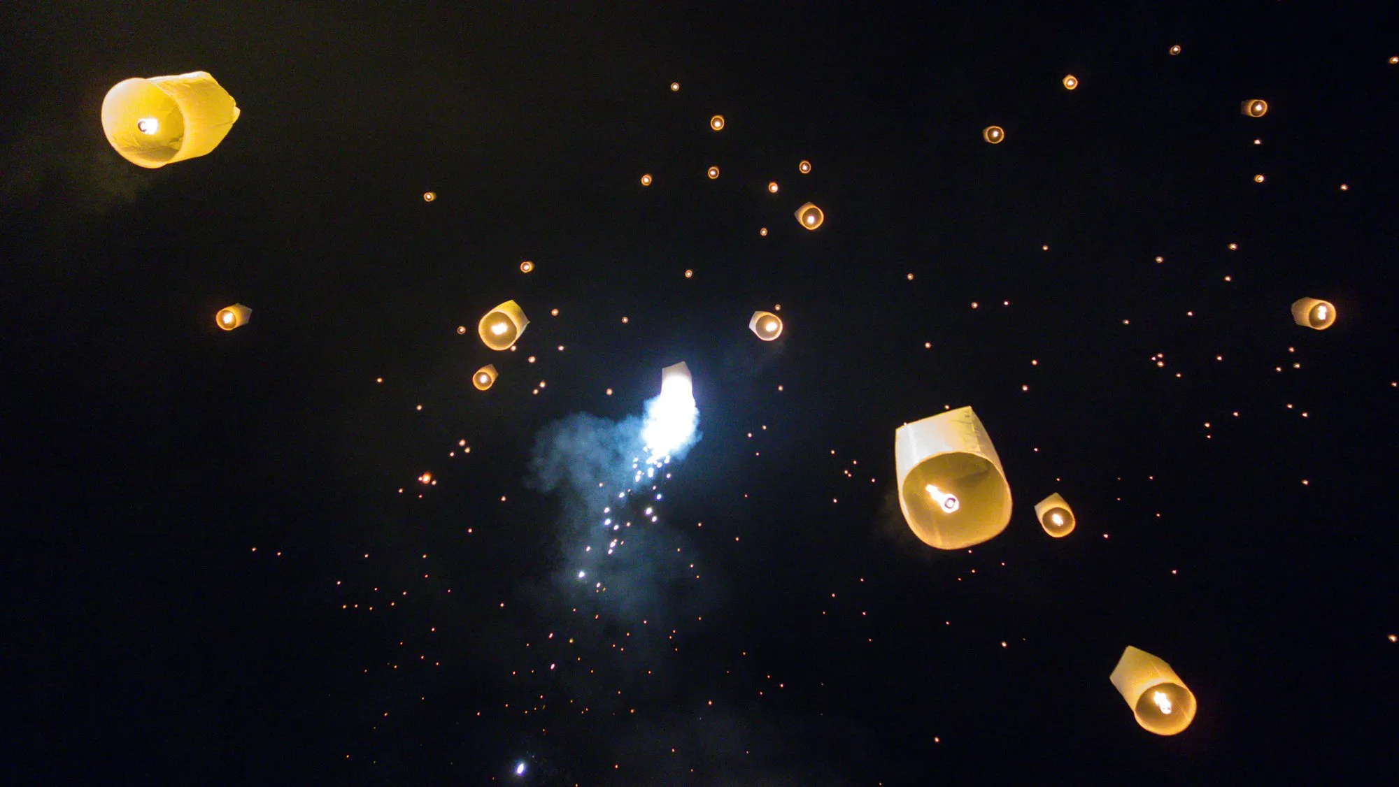 Thousands of lanterns rising into the night sky at the Yi Peng festival